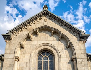 Ornate stone building gable against cloudy blue sky