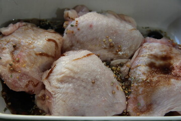 pieces of raw chicken covered with spices, in a baking dish, large