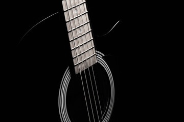 black acoustic guitar on a black background, silhouette. black and white, close-up
