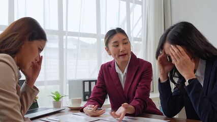 Stressed asian businesswomen listening to manager's reprimand in meeting