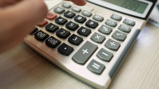 Close-up of a hand pressing buttons on a calculator