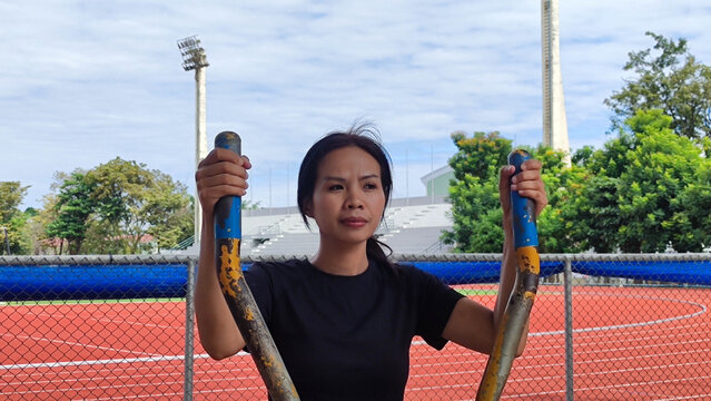 Active Woman Exercise on Elliptical: A focused woman works out on an elliptical machine outdoors, maintaining an active and healthy lifestyle with determination and strength.