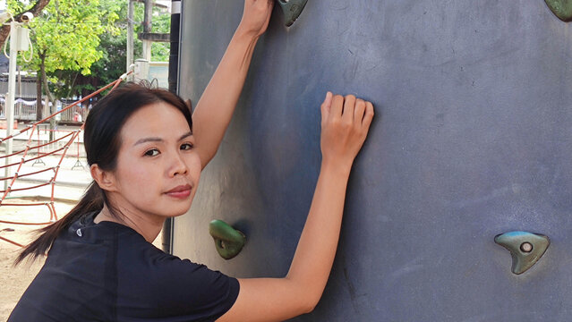 Climbing Challenge: A focused individual tackles a challenging climbing wall, showcasing strength and determination in an outdoor setting. 