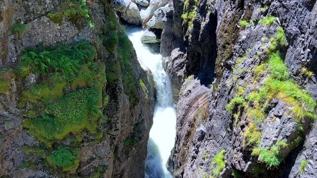 Karachay-Cherkessia. Summer mountains of the North Caucasus, Dombay district. View of the waterfall in the mountains. Devil's Mill Waterfall, incredible gorge, top view. 4K
