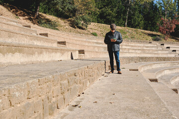 Elderly man standing on outdoor steps using his phone