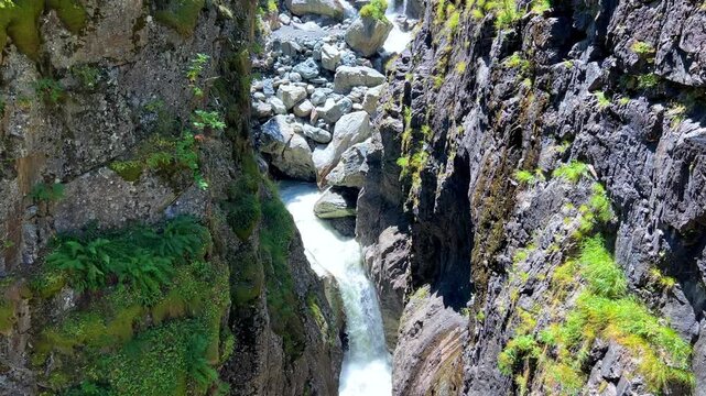 Karachay-Cherkessia. Summer mountains of the North Caucasus, Dombay district. View of the waterfall in the mountains. Devil's Mill Waterfall, incredible gorge, top view. 4K