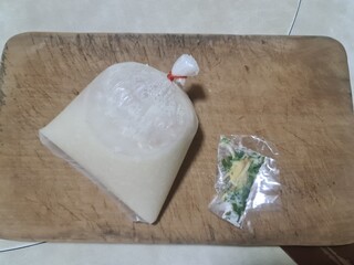  minced pork porridge for breakfast in plastic bag Thai style with ginger and green spring onion isolated on wood board