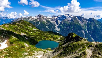 High alpine lake nestles in green slopes, jagged peaks with snow patches under a cloudy sky in a mountain range