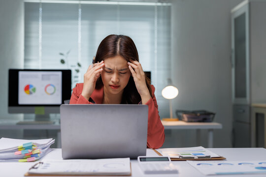 Stressed businesswoman suffering headache working late at office