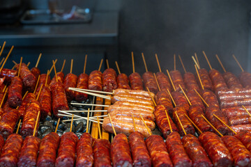 Street vendors grill spicy skewers in a market