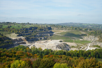 Panoramic View Of A Large Open-pit Quarry At Black Rocks, Cromford, Derbyshire, Nestled Among Vibrant Autumn Woodlands And Rolling Countryside.