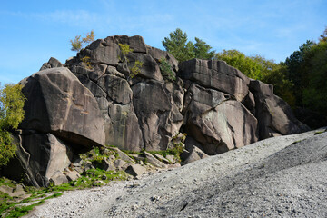 Impressive Natural Rock Formation At Black Rocks, Cromford, Derbyshire, Featuring Rugged Grey Boulders Under A Bright Blue Sky With A Gravel Path Leading Up.