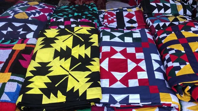 Close-Up Shot of Brightly Colored Traditional Patchwork Textiles and Quilts Displayed in Market