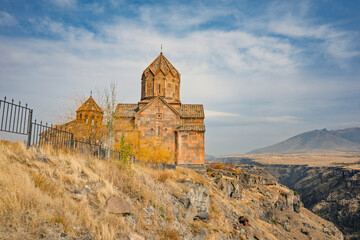An Armenian Hovhannavank monastery church with a steeple sits on a hillside