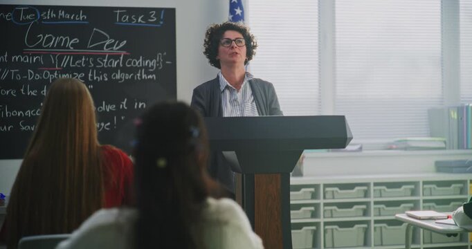 Enthusiastic Smiling Woman Explains Concept Students During Interactive Classroom Discussion. Innovative US Education System, Active Learning, Student Participation, Communication Based Teaching.