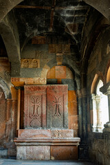 The inside of a Armenian Hovhannavank monastery church with a red and brown Khachkar