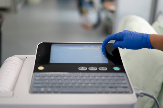 Doctor hand operating ecg machine performing cardiac test