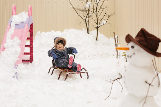 Child playing with sled having winter fun
