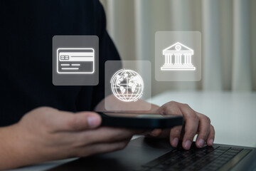 Fintech and digital banking concept. A person uses a smartphone and laptop for online financial services, showing virtual icons for credit card payment, global transactions, and mobile banking.