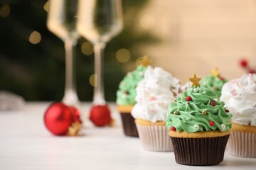 Tasty festive cupcakes on white table, selective focus. Christmas treat