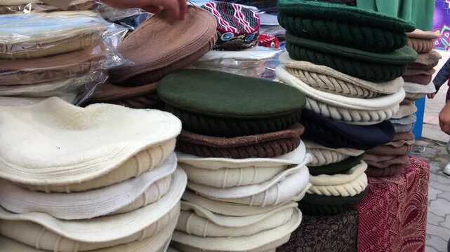 Pakol Hats in Different colors Collectios are display in wall corner, traditional pakol hat on display in lok virsa mela, islamabad	