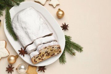 Cut traditional Stollen cake, cookies and Christmas decor on white table, flat lay. Space for text