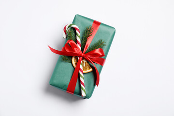 Decorated Christmas gift with candy cane on white background, top view