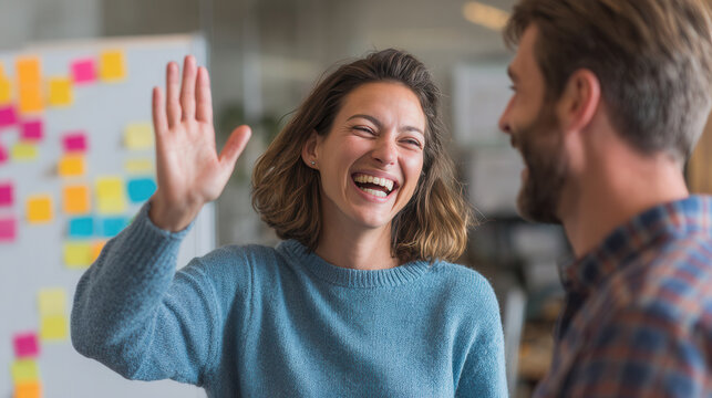 Joyful conversation between colleagues in a modern office setting during daylight hours