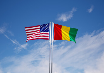 flags of guinea and United States of America over blue sky background.