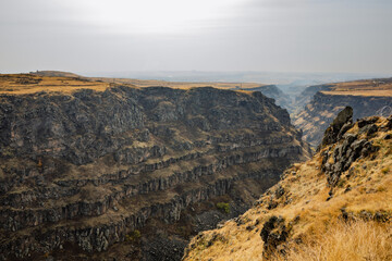 A rocky canyon with a gray sky in the background