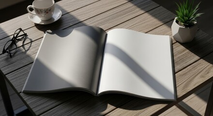Open book on wooden table with coffee and glasses in sunlight.