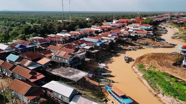Aerial view of the stilt houses of kampong phluk floating village along the muddy river banks near tonle sap lake.