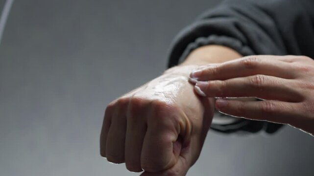 A man applies a healing ointment to his hand to reduce inflammation from a hand injury.
Hand injury and tendon strain.
Medicine, hand, cream, ointment, bruise, pain