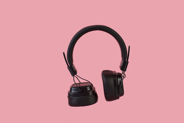 Two-tone silver and brown wireless headphones, Headphones isolate on pink background. Wireless...