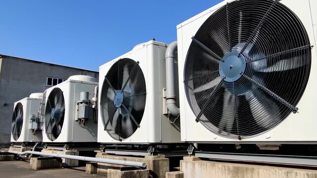 A row of outdoor industrial air conditioning units with large fans, blue sky background