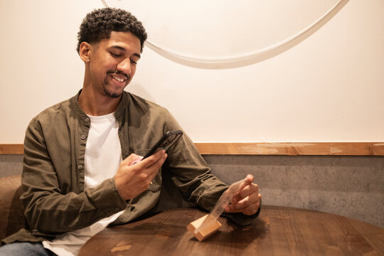 Hispanic man scanning a restaurant's QR code menu.