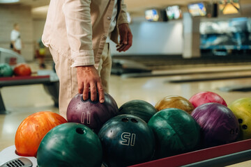 Taking the ball. Close up view of man that is playing bowling