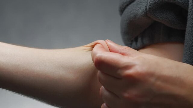 Tight skin on the arm.
Aging and sagging skin on the body
A person pinching the thin skin on the arm
