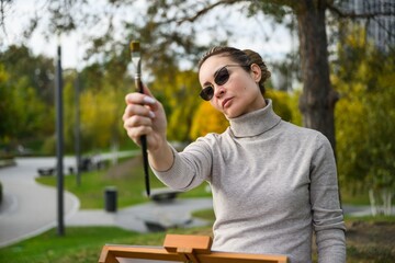 Woman painting outdoors in a park.