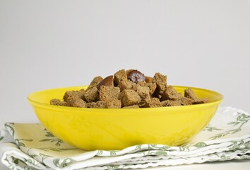 Close-up of yellow plate with delicious croutons on cloth napkin
