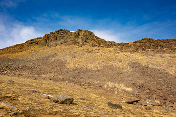 A rocky hillside with a clear blue sky in the background