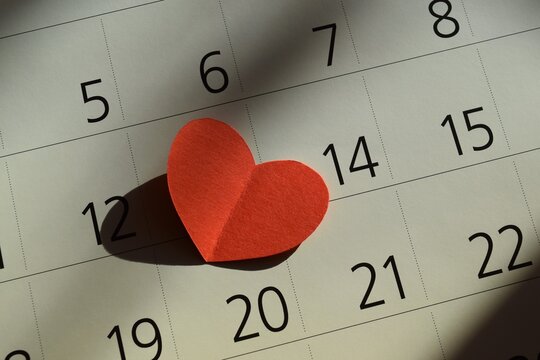 Red paper heart on calendar