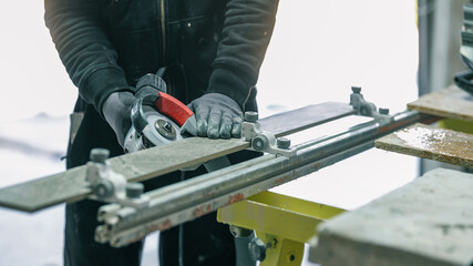 A construction worker using a grinder to cut a tile for installation