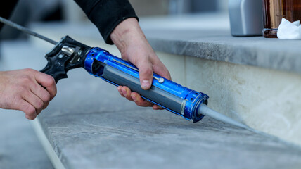 Applying sealant with a caulking gun for home improvement and construction