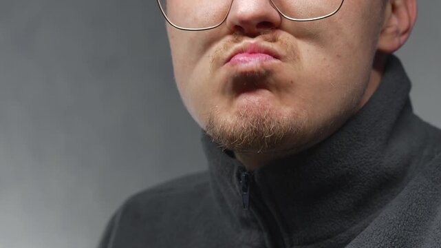 A close-up of a pensive man's facial expression.
A man's face, nervous before an important meeting.
Biting the lip from intense nervous tension.
Stress and anxiety