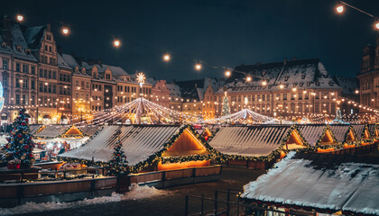 Festive European Christmas Market at Night with Wooden Stalls and Lights