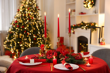 Stylish Christmas table setting with plates, festive decor and burning candles indoors