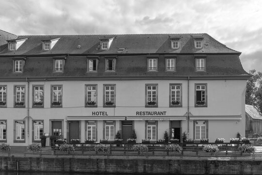Strasbourg, France- July 9, 2025: Regent Petite France, a hotel, spa and restaurant building exterior seen across river Ill on Place Benjamin Zix street in black and white