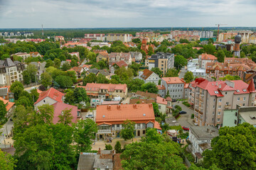 Elevated panoramic view of the resort town of Zelenogradsk, showcasing residential buildings with orange roofs surrounded by lush green trees