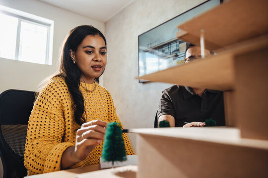 Young professionals designing a scale model at an architectural workspace